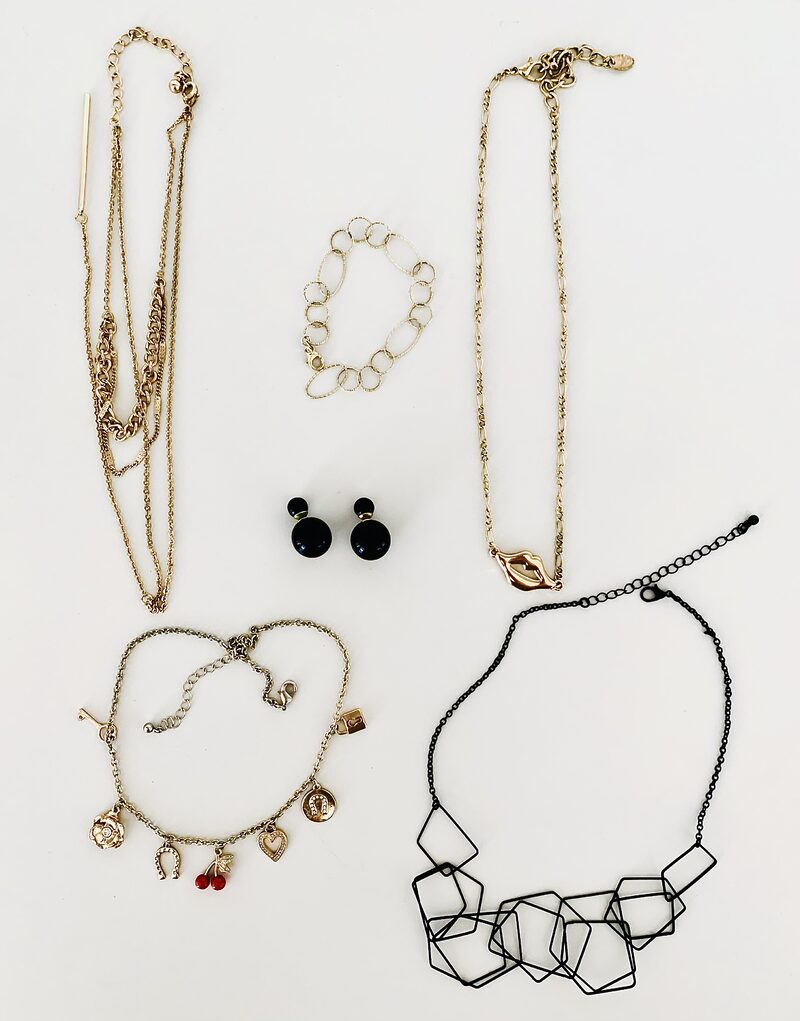 Photo of six pieces of costume jewelery on a white table
