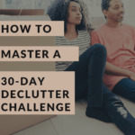 Photo of a young couple sitting on the floor next to a pile of packed up boxes. The woman looks a bit tired, yet pleased, and her man is smiling with satisfaction. Caption reads: How to Master a 30-Day Declutter Challenge. Best tips.