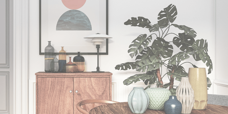 Mid-century modern inspired interior with a teak sideboard, collection of Danish pottery vases, and a large monstera plant.