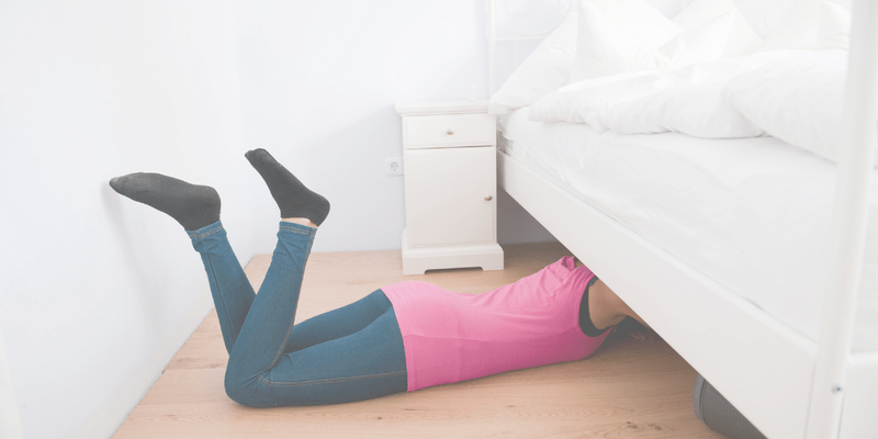 Image showing lady lying on floor on her belly, digging under her bed. Caption reads Why Under Bed Storage is a Bad Idea and post explains why storing things under the bed is dirty, causes dust, mildew and mould, and blocks air circulation to the mattress.