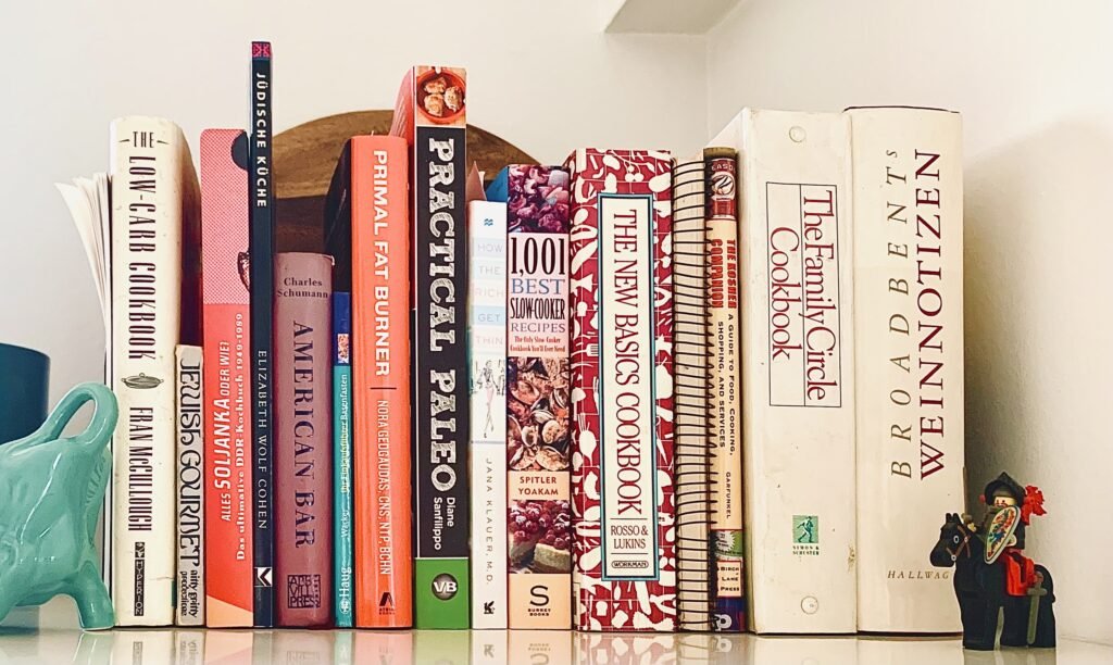 Cookbook collection on a kitchen shelf.