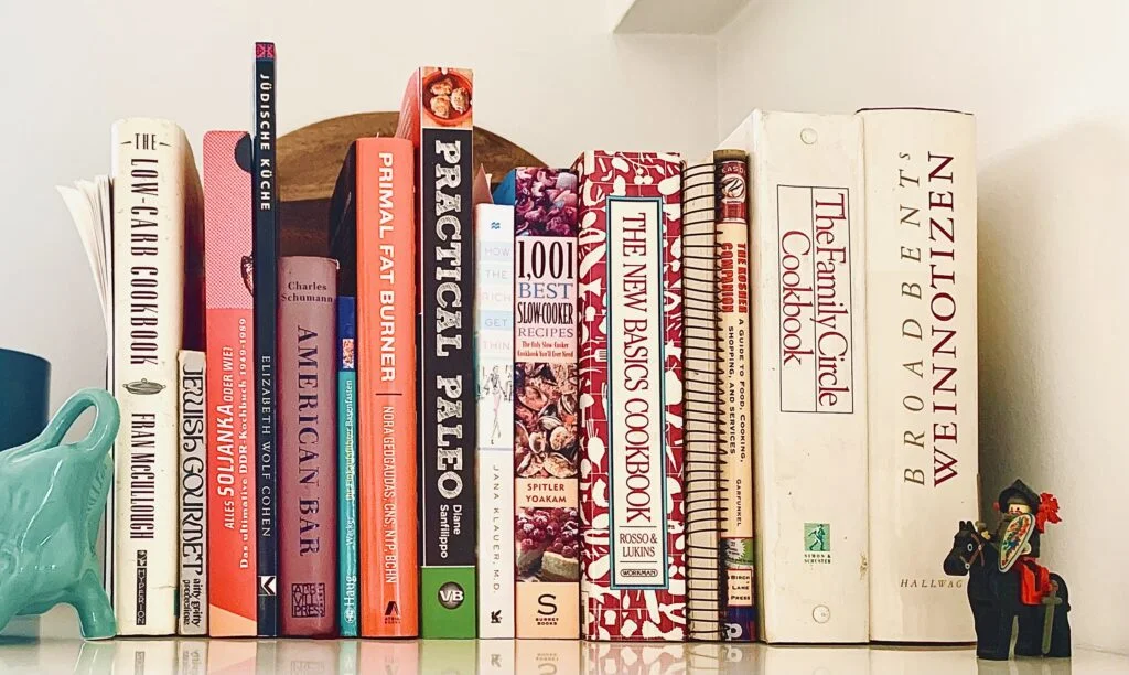Cookbook collection on a kitchen shelf.