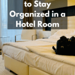 Photo of very organised hotel room. The bed is neatly made and there is a small black Prada backpack on top of the bed. Caption reads 7 easy ways to stay organized in a hotel room.