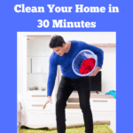 Photo of a young white man with dark hair wearing slippers, a blue jumper and black trousers. He's holding a round laundry basket in his left hand while he reaches with his right hand to pick up dirty clothes lying on the floor. Caption reads: 8 step checklist to clean your home in 30 minutes.