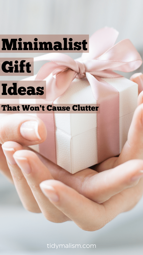 Photograph of a manicured, female hand against a pale pink backdrop, holding a tiny minimalist gift.