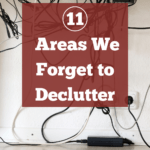 Photo of a mess of cables and cords hanging underneath what appears to be a desk or workstation. A haphazardly taped powerstrip hangs from the underside of the desk and the cables are all tangled up. Caption reads: Clutter busting. 11 areas we forget to declutter.