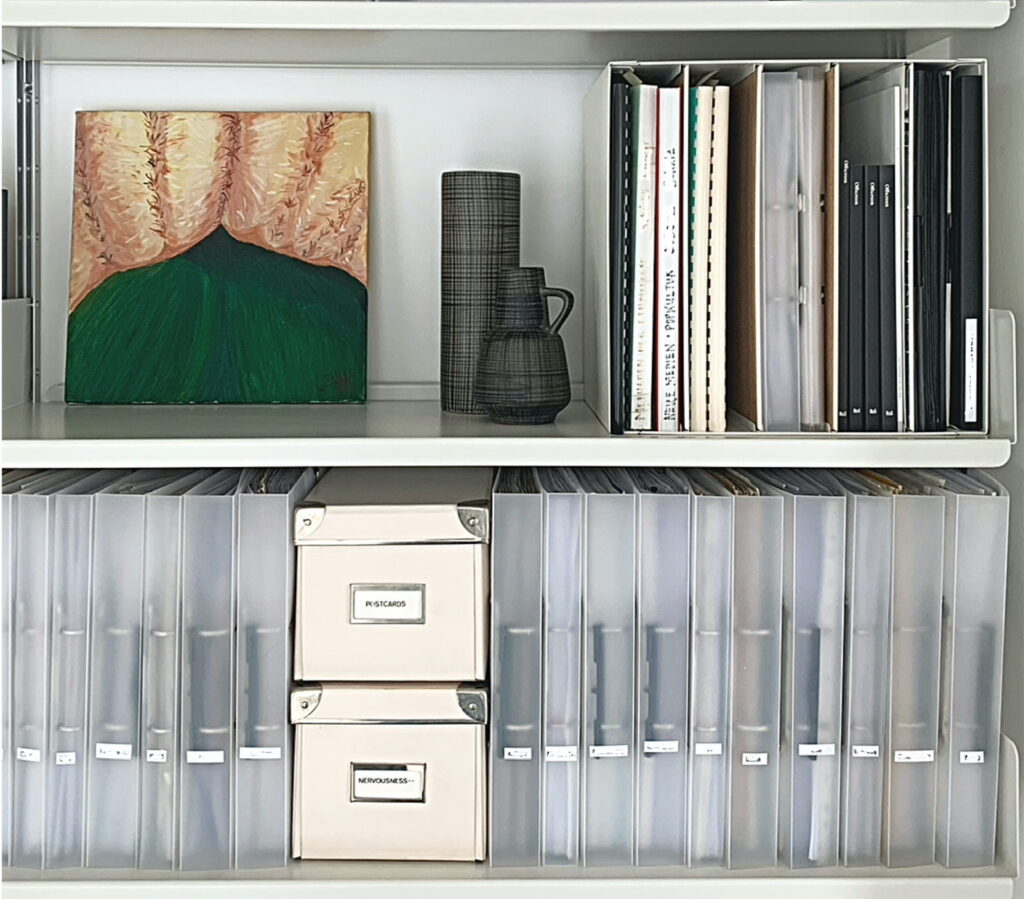 Daily organising hacks for paperwork archives include using uniform looking, slim binders to organise paper archives like on this shelf.