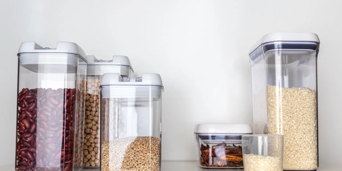 Small, organized pantry with dry staples in clear containers.