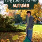 Teenage boy raking leaves in his home's yard to help get organized for the fall.