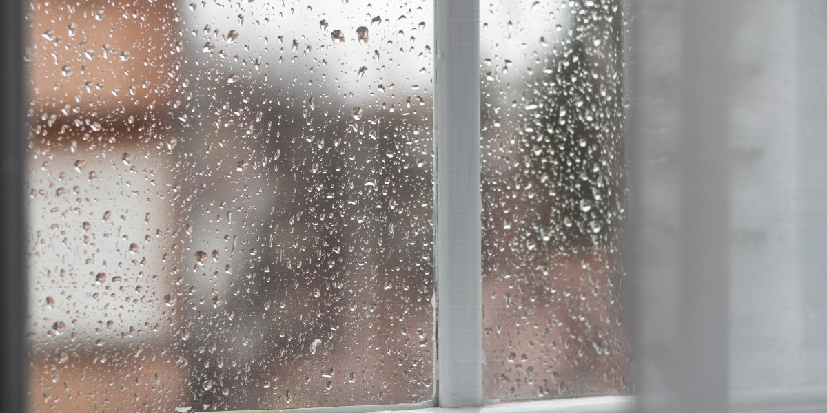Raindrops on a white-trimmed windowpane.