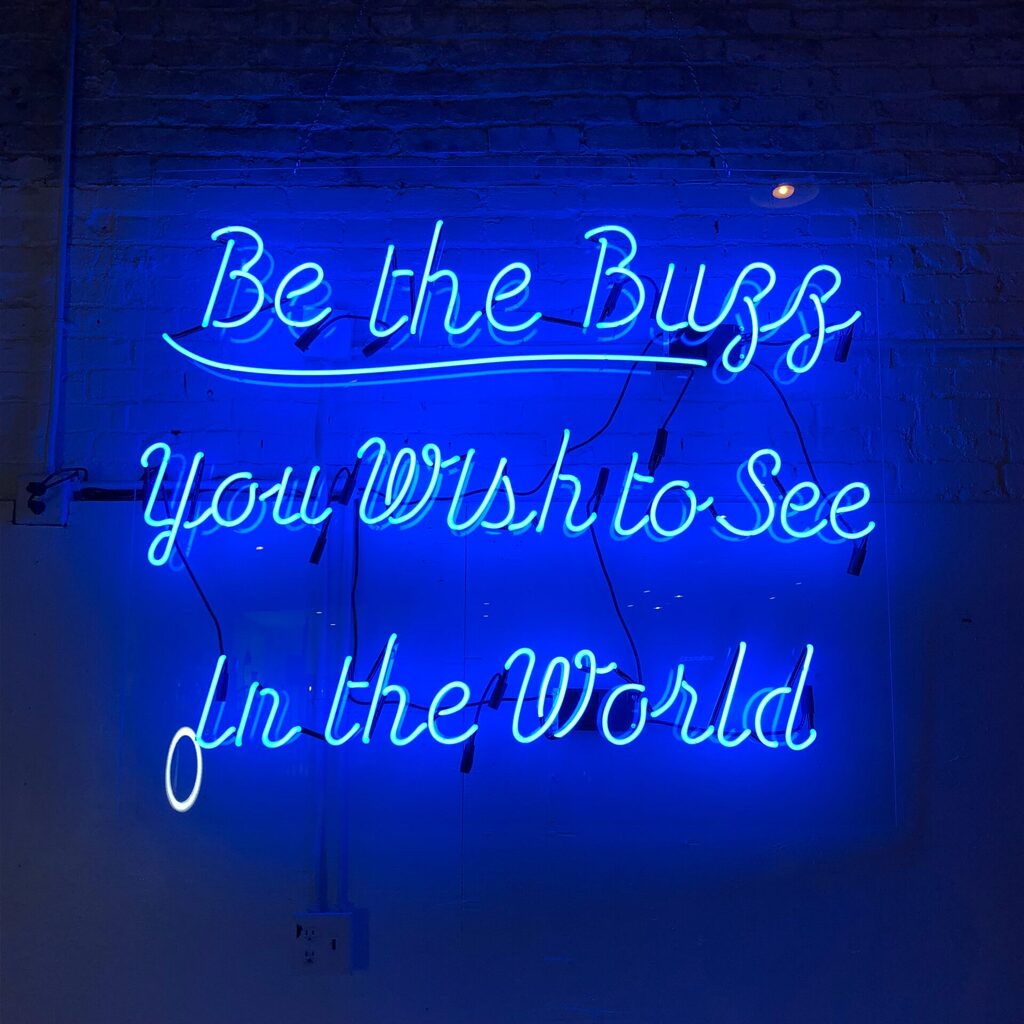 Blue neon sign with a "good vibes" message. There's a difference between toxic positivity and optimism, and the latter is way healthier. Photo by Tanya Santos.