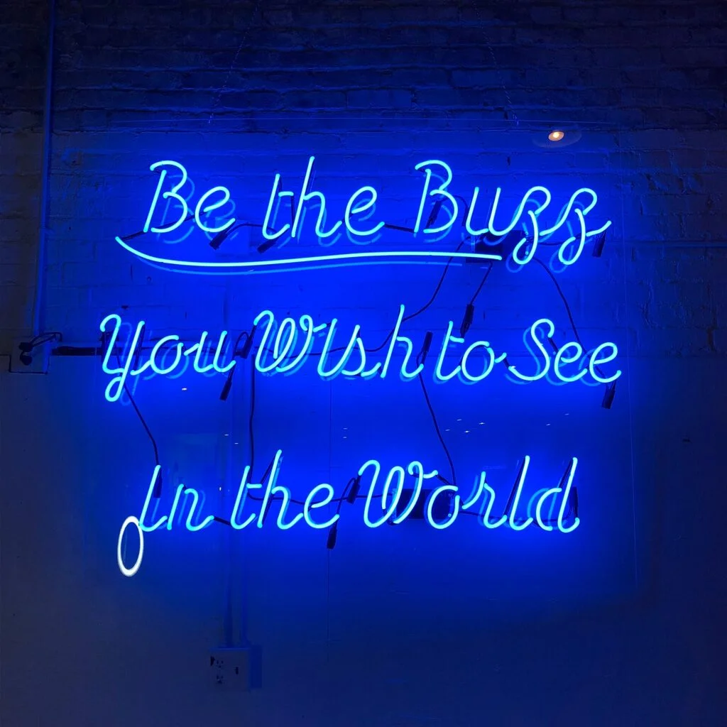 Blue neon sign with a "good vibes" message. There's a difference between toxic positivity and optimism, and the latter is way healthier. Photo by Tanya Santos.