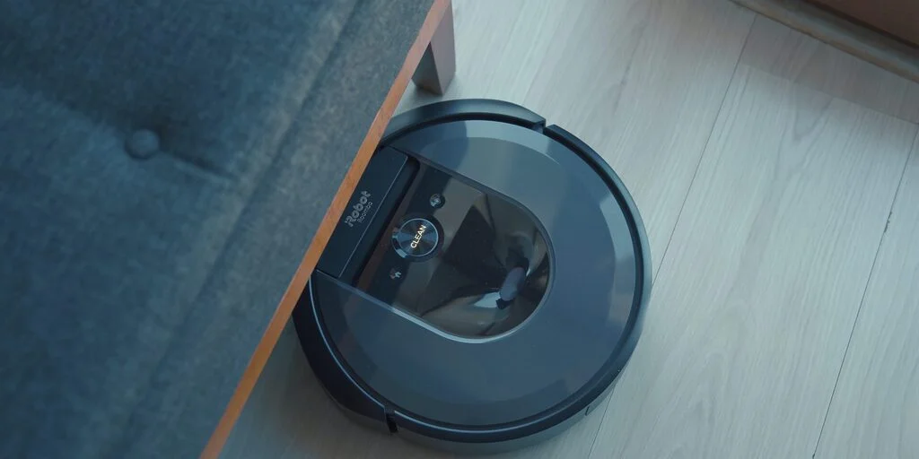 an iRobot hoover cleaning underneath furniture. These devices are good cleaning hacks for disabled people.
