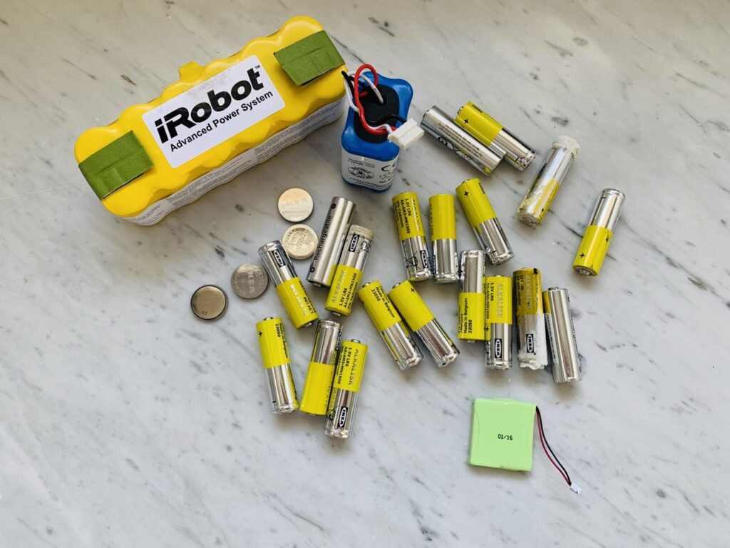 A lot of old batteries, most of them bright yellow, ready to be taken to the recycling center during a 30 day household declutter challenge.
