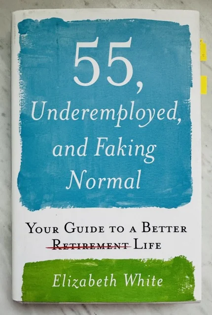A hardcover book, 55, underemployed and faking normal, by Elizabeth White, on a kitchen counter.
