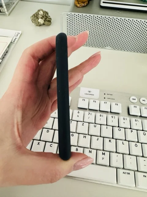 Hand holding a SanDisk SSD to show how thin it is.